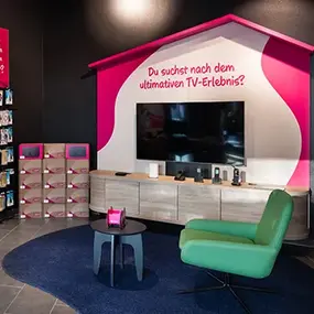TV-Ausstellung mit großem Fernseher, Sofa und Wohnbereich im Elektronikmarkt