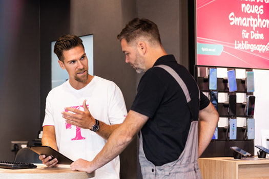 Telekom Mitarbeiter berät Kunden im Shop zu Smartphones und Tarifen